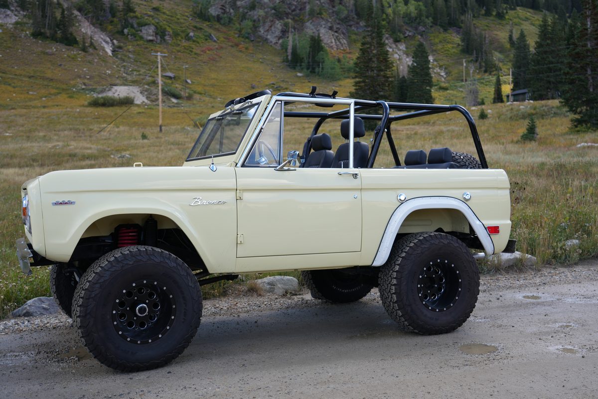 Close passenger-side profile showing the white rear fender flare, roll cage and Bronco badging